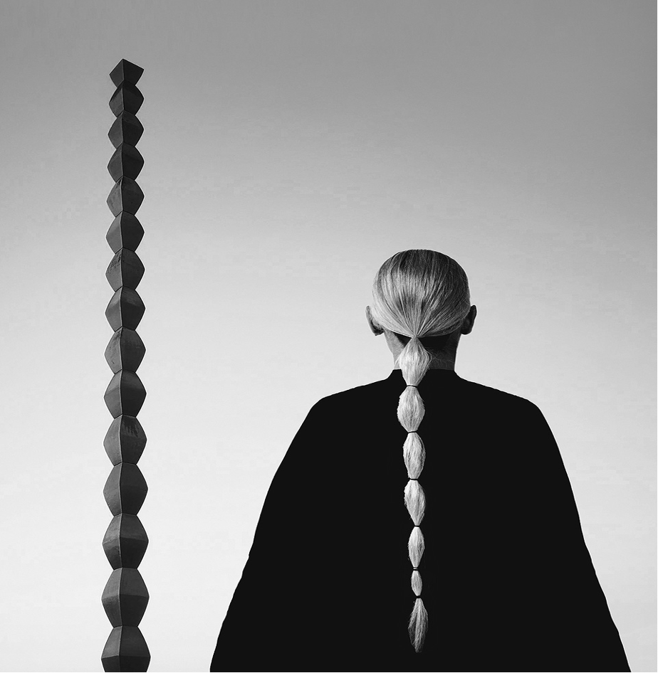 Femeie contemplând Coloana Infinitului de Brâncuși